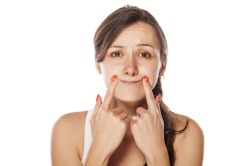 woman holding lips in smile position